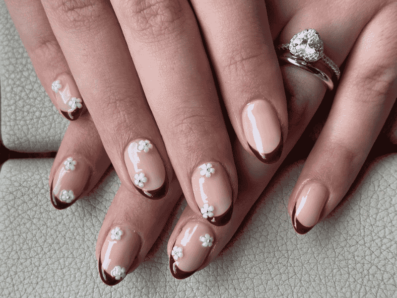 Riri Nails Oman natural nails Gel manicure featuring elegant French tip and floral nail art
